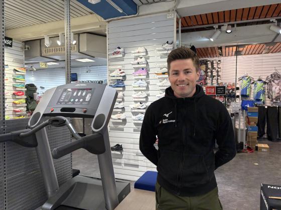 Mann ved siden av tredemølle i en sportsbutikk